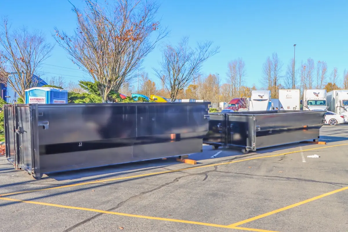 Professional dumpster rental service with roll-off container on residential driveway in Orchards